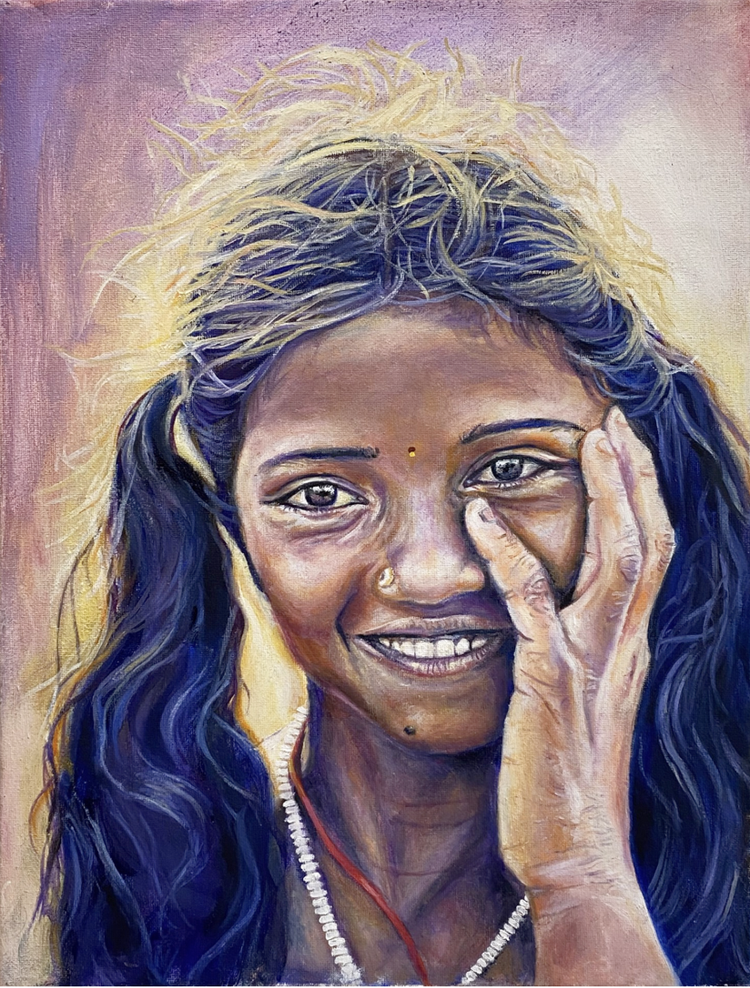 Portrait of a smiling woman with a bindi, one hand resting near her eye.
