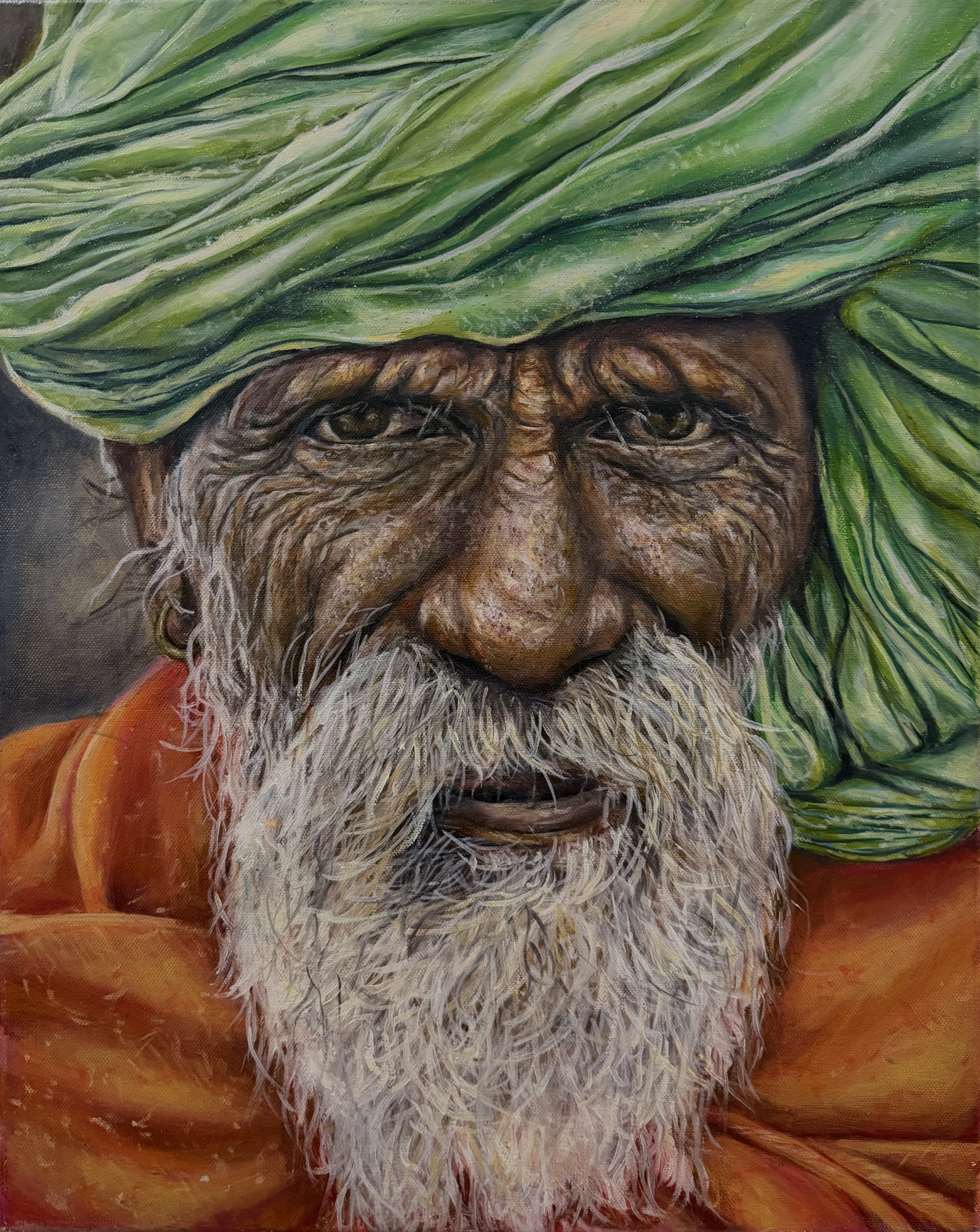 Portrait of an older man with a white beard, a green turban, and an orange robe.